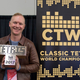 Jonas Neubauer holding up his seventh trophy after winning the most recent World Championship. Image via Classic Tetris World Championship by James Rexroad.